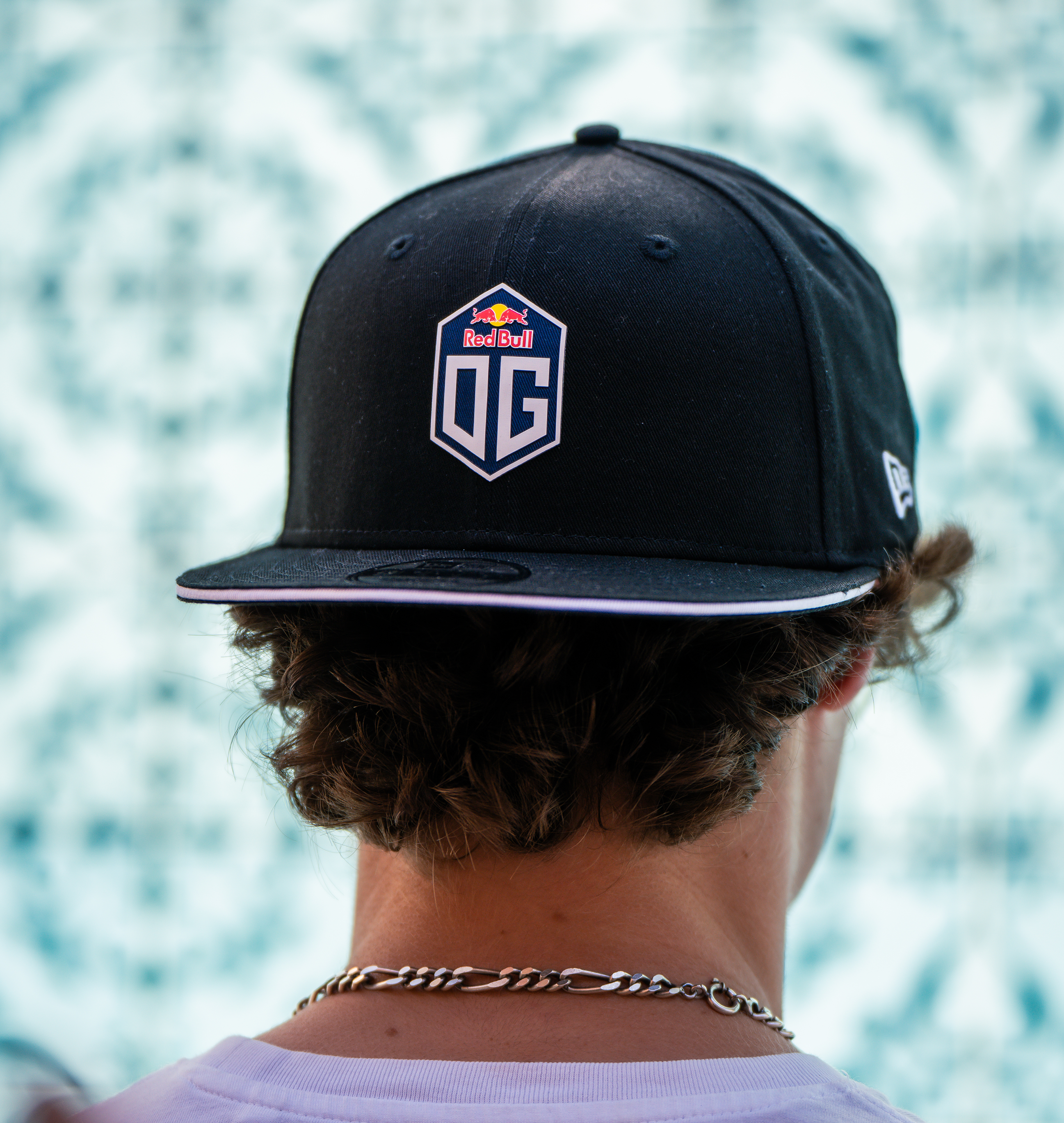Model wearing a reversed dark blue snapback cap with the OG logo on the front and the New Era logo on the side.