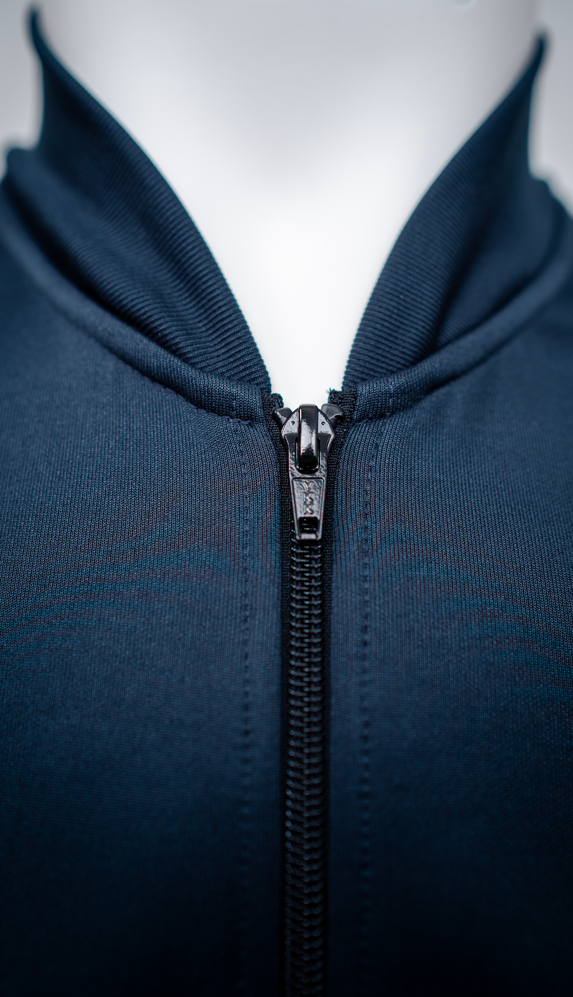 Close-up view of the pro jacket in dark blue color, focusing on the neck area with a zipper.