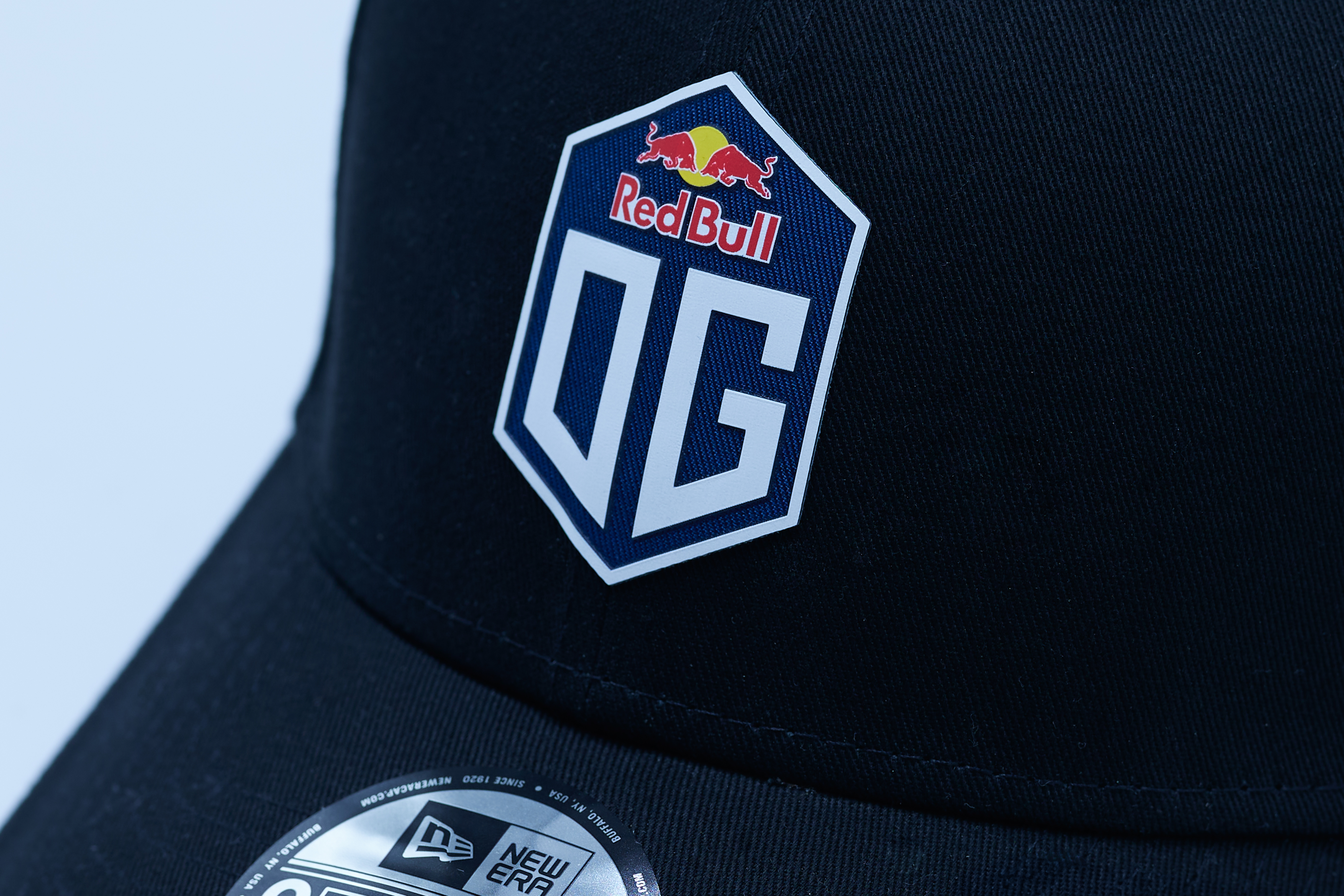 Close-up of a dark blue cap with the OG logo prominently displayed on the front.