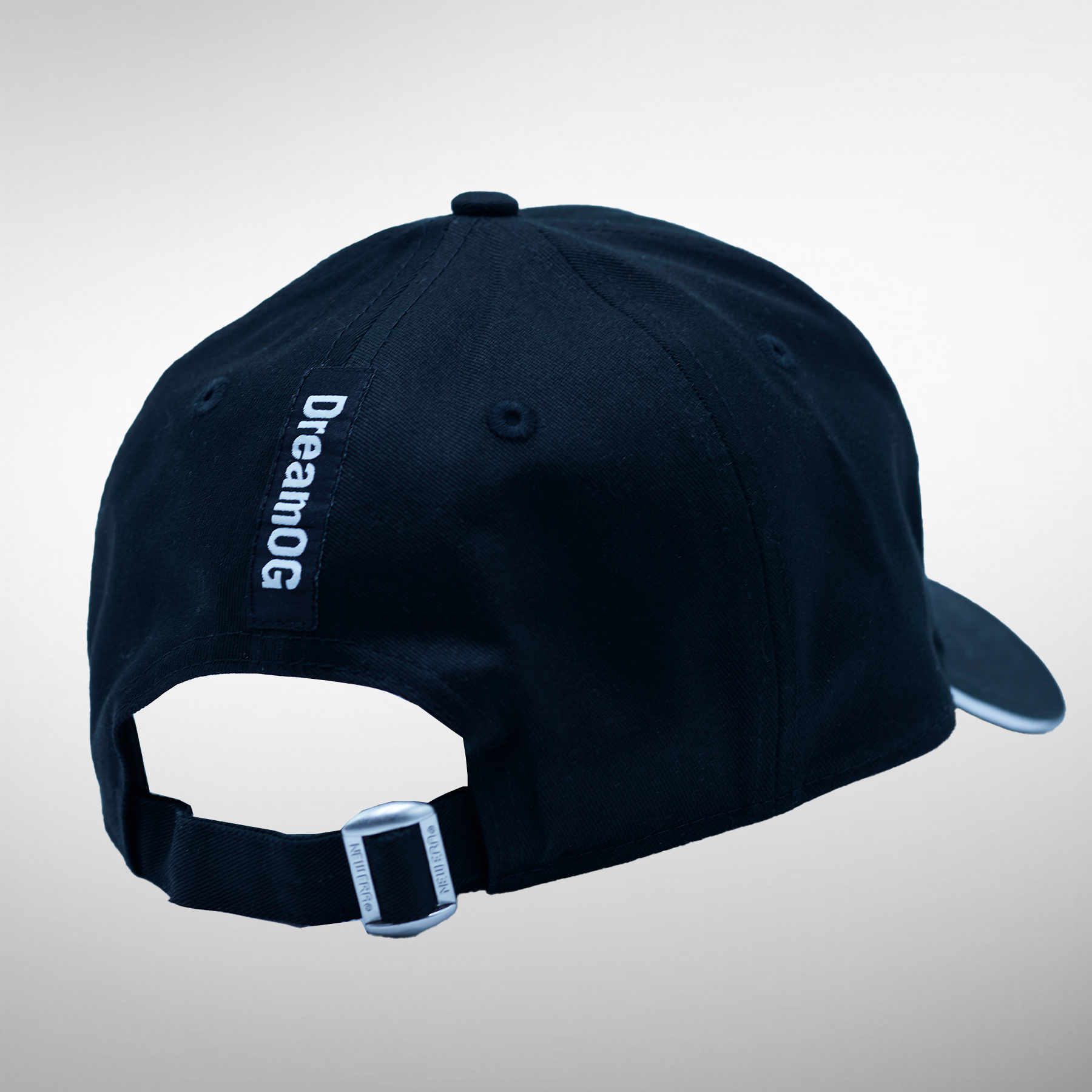 Back view of a dark blue cap featuring the 'DreamOG' slogan prominently displayed.