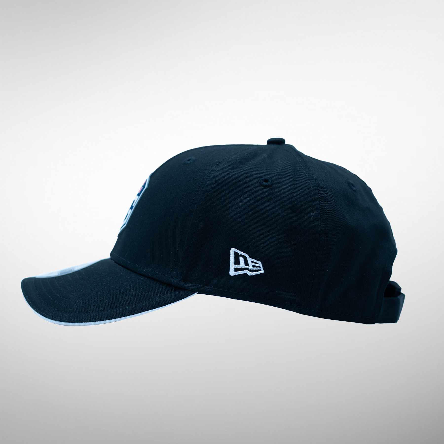 Side view of a dark blue cap featuring the OG logo on the front and the New Era logo on the side.