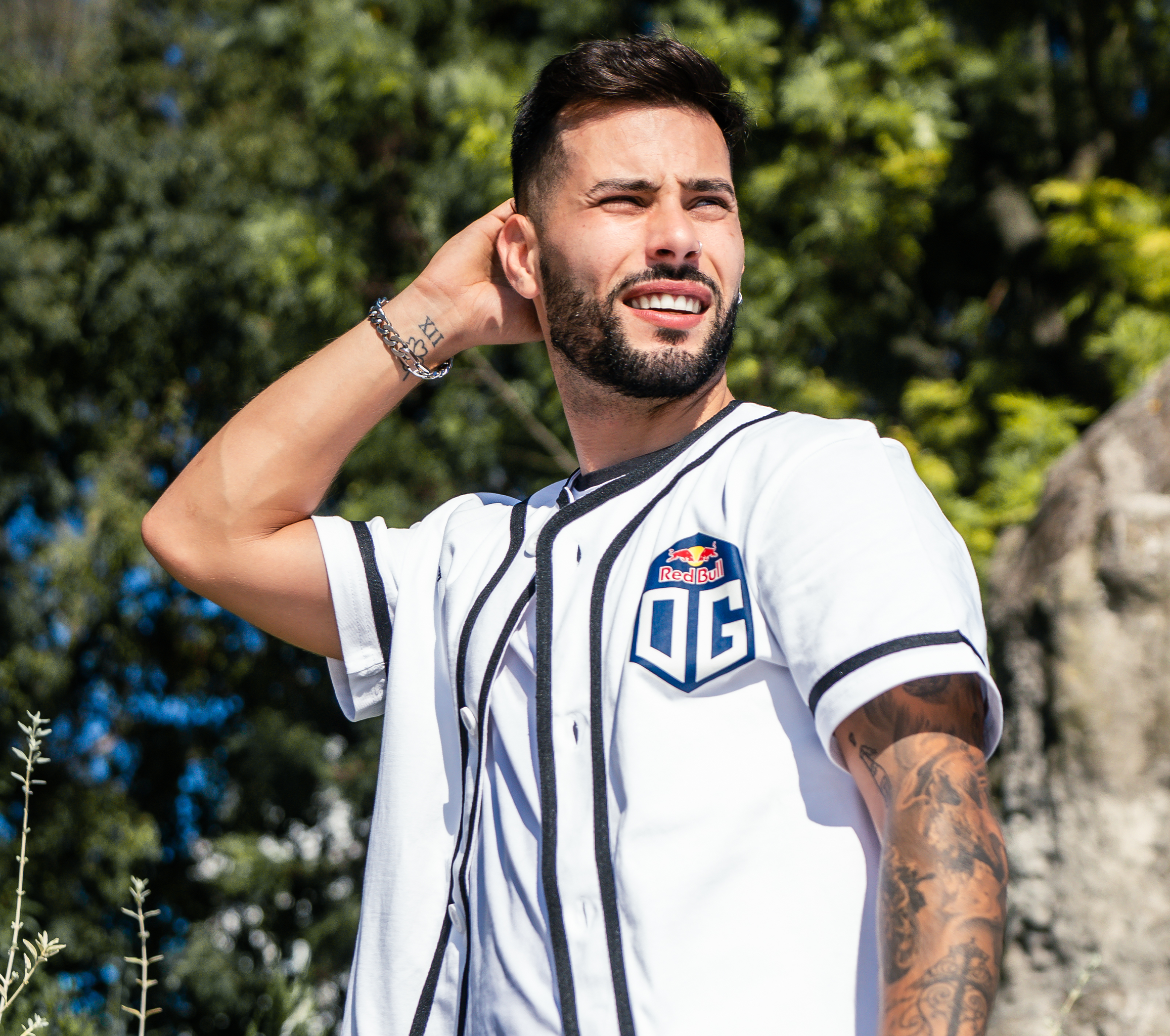 A model wearing a black and white baseball tee with OG logo on the front, posing against a plain background to showcase the casual and sporty design of the shirt.