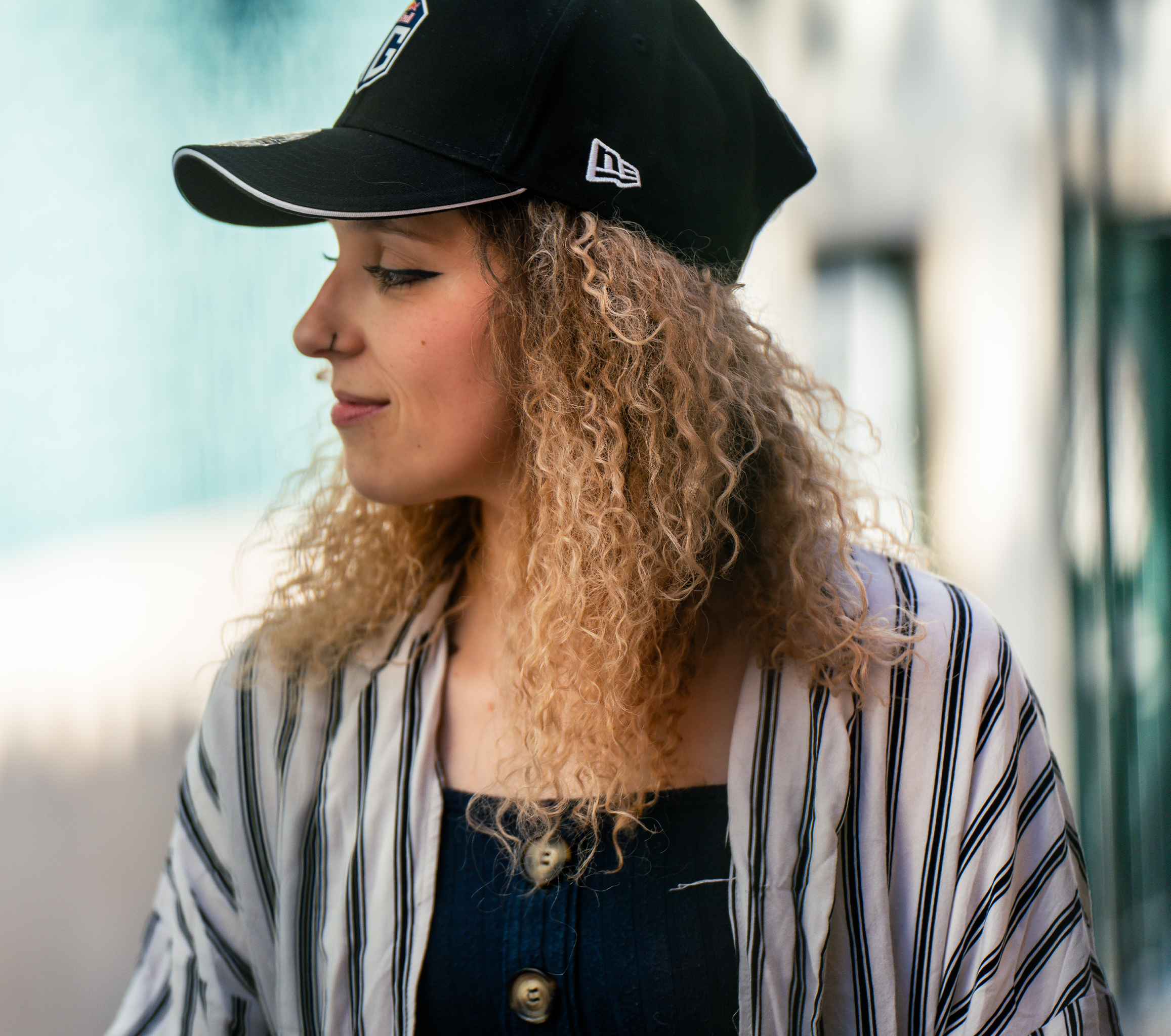 A female model wearing a dark blue cap with the OG logo prominently displayed on the front and the New Era logo on the side.