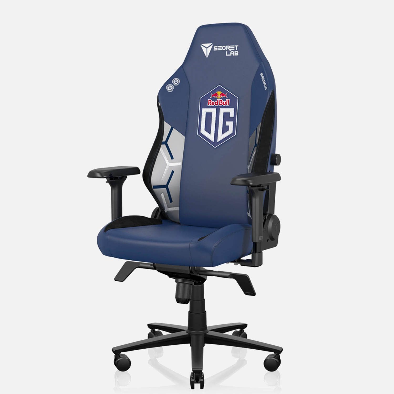 Secretlab Titan gaming chair in dark blue fabric, customized for Esports Team OG, featuring ergonomic design, adjustable armrests, and a large backrest with the Secretlab logo in gold. The chair is set against a white background, highlighting its premium build and association with the Red Bull-sponsored team OG.